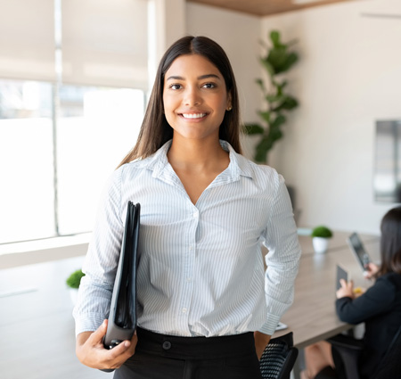 Professional woman holding binder in conference room